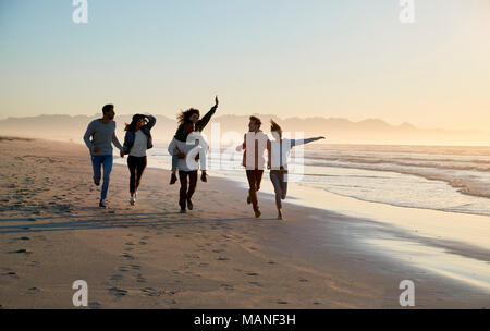 Gruppe von Freunden Spaß entlang Winter Beach Zusammen läuft Stockfoto