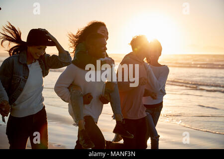 Gruppe von Freunden Spaß entlang Winter Beach Zusammen läuft Stockfoto