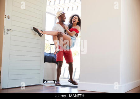 Der Mensch trägt Frau über dem Schwellenwert von Honeymoon Mietwagen Stockfoto