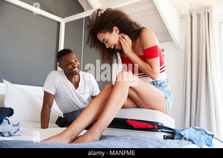 Paar zu schließen vollständige Urlaub Koffer Versuchen, im Schlafzimmer Stockfoto