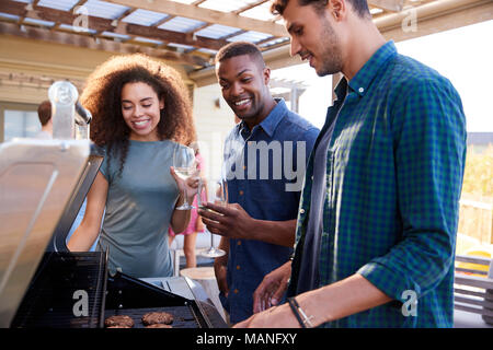 Eine Gruppe von Freunden mit Grill zu Hause zusammen Stockfoto