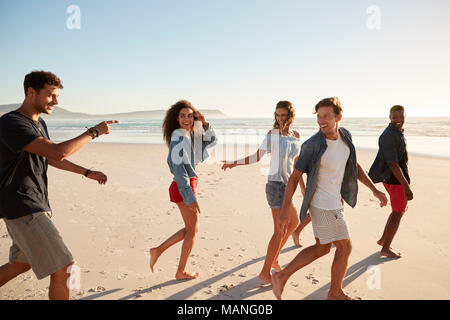 Eine Gruppe von Freunden auf Urlaub gehen entlang Beach zusammen Stockfoto