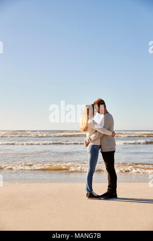 Romantisches Paar, das im Winter Strand Stockfoto