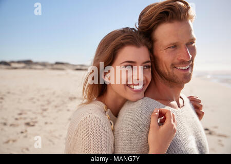 Romantisches Paar, das im Winter Strand Stockfoto