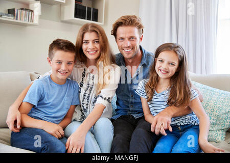 Portrait von lächelnden Familie sitzt auf dem Sofa zu Hause zusammen Stockfoto