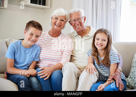 Portrait von Enkel sitzt auf einem Sofa mit Großeltern Stockfoto