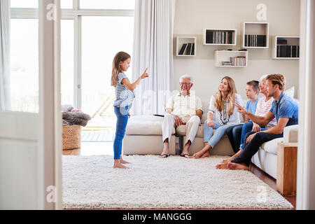 Multi-Generation Familie sitzt auf dem Sofa zu Hause spielt Scharaden