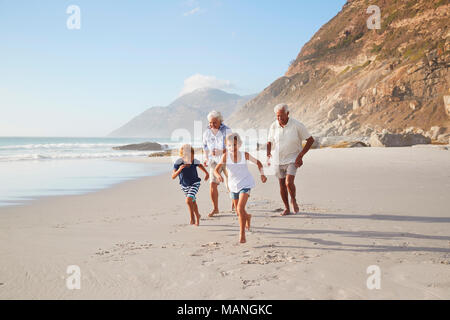 Großeltern Entlang Strand mit Enkelkindern im Sommerurlaub