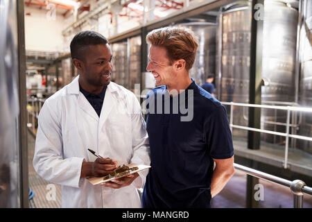 Zwei Männer lächelnd, die während einer Inspektion in einem weinbereitung Factory Stockfoto