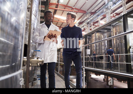 Zwei männliche Mitarbeiter machen eine Inspektion an einem Wein Factory Stockfoto