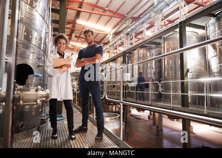 Männliche und weibliche Wein factory Techniker lächelnd in die Kamera Stockfoto