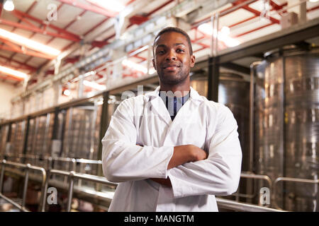 Portrait einer jungen männlichen Schwarzen Techniker an einem Wein Factory Stockfoto