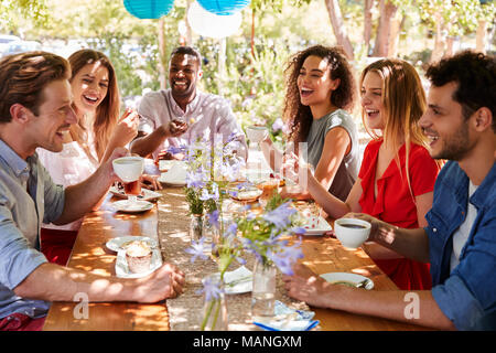 Sechs junge erwachsene Freunde Kaffee nach dem Essen im Freien Stockfoto