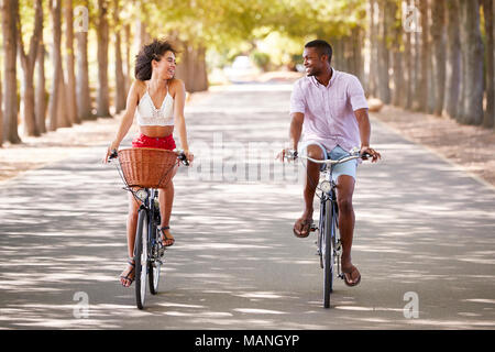 Junge Mixed Race Paar Reiten Fahrräder an jedem anderen Suchen Stockfoto