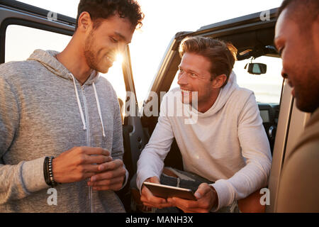 Drei männliche Freunde auf eine Reise mit einem Tablet, in der Nähe Stockfoto