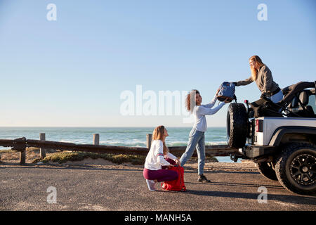 Drei junge Erwachsene Freundinnen Rucksäcke entladen aus ein Auto Stockfoto