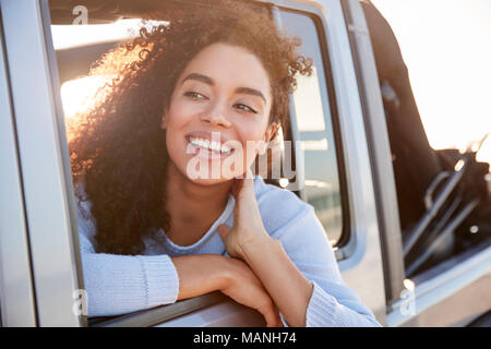 Junge Frau aus dem offenen Fenster eines Autos suchen Stockfoto