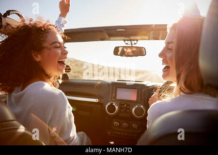 Junge Erwachsene Freundinnen Spaß fahren eines oben offenen Auto Stockfoto