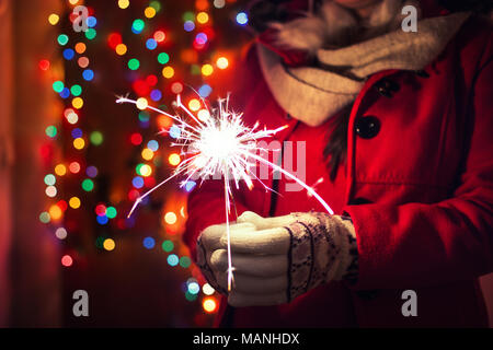 Frau mit bengalischen Lichter über bokeh Hintergrund. Weihnachten Konzept. Stockfoto