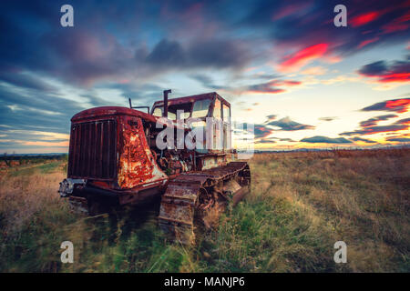 Schönen Sonnenuntergang über Feld und alten verrosteten Traktor. HDR Stockfoto