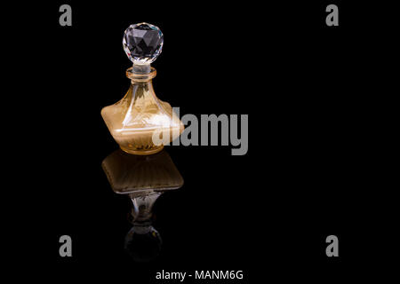 Nahaufnahme von traditionellen luxuriösen arabischen Oud Öl Parfüm in einem wunderschönen handgemachten Klarer Kristall Glas Glas Flasche und Glas Dropper isoliert auf Schwarz Stockfoto