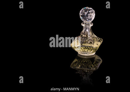 Nahaufnahme von traditionellen luxuriösen arabischen Oud Öl Parfüm in einem wunderschönen handgemachten Klarer Kristall Glas Glas Flasche und Glas Dropper isoliert auf Schwarz Stockfoto