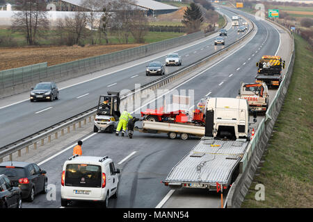 Abschleppwagen Arbeitnehmer Reinigung Wreckage von Verkehrsunfall auf Landstraße, Notdienste Antwort Stockfoto