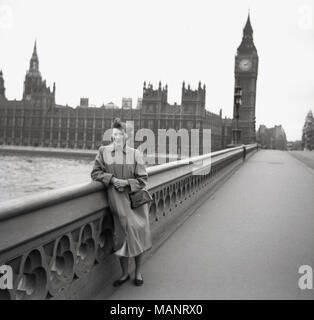 1951, historische Bild einer Frau, stützte sich auf die sicherheitsschienen oder brüstung auf die Westminster Bridge, mit dem britischen Parlament im Hintergrund. Erstaunlich, angesichts dieses Bild am Tag genommen wurde, die Brücke ist komplett leer, mit nicht eine einzige andere Person sowieso auf dieser Seite der Brücke. Vielleicht war es ein Sonntag Morgen und man kann vermuten, dass, da es nicht viele Jahre nach WW2, und dass London hatte sehr wenige Besucher. Stockfoto