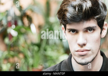 Porträt eines jungen Mannes an der Kamera, zu denken und zu schweren suchen, im Freien. Stockfoto