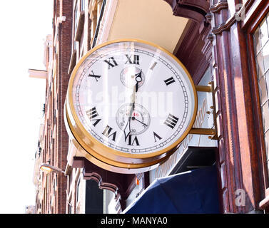 Alte oder antike Uhr auf einem Haus Fassade oder Gebäude Exterieur. Wunderschöne goldene Uhr. Stockfoto