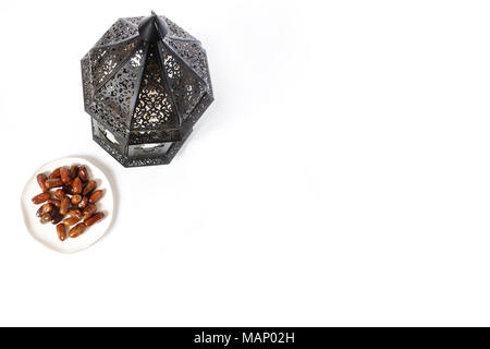 Dekorative dunkel Marokkanischen, Arabische Laterne und Platte mit Datum Früchte auf dem weißen Tisch. Grußkarte für muslimische heilige Monat Ramadan Kareem. Festliche ba Stockfoto