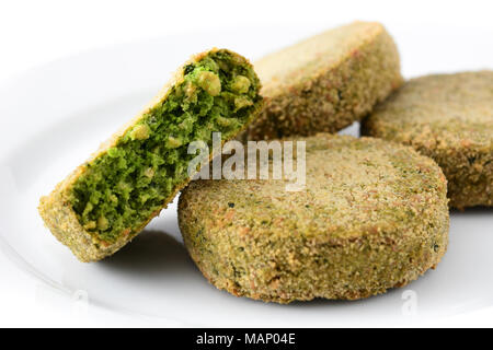 Gegrilltes gemuese Hamburger mit Spinat und Erbsen auf weiße Platte auf weißem Hintergrund Stockfoto