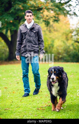 Mann, der seinen Hund im Herbst Park Stockfoto