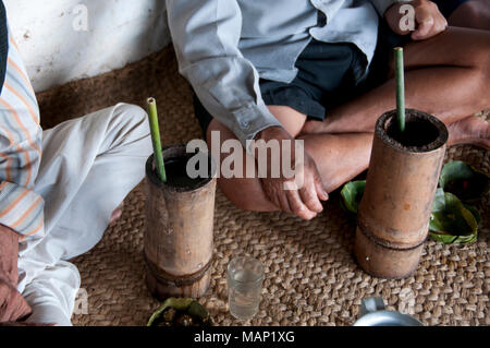 Nepal 2014. Pangma Dorf. Nuagi Feier. Männer sitzen gekreuzten Beinen auf einer Matte trinken Hirse Bier Stockfoto