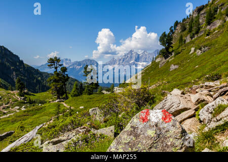 Wandern mark Zeichen rot weiss rot auf Rock am Berg Reiteralm mit Fernsicht auf die Berge Dachstein in Österreich lackiert Stockfoto