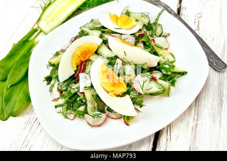 Salat mit Radieschen, Gurken, Sauerampfer, grünen und Eier, gekleidet mit Mayonnaise und Sauerrahm in eine weiße Platte auf dem Hintergrund der Holzplatte Stockfoto