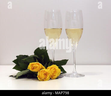 Zwei Gläser Champagner/Sekt mit drei gelbe Rosen. Perfekte still life Foto für Frühjahr, Sommer oder jede Art von Feier. Stockfoto