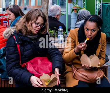 Zwei Frauen Essen in der Nähe von Borough Markt, Southwark, London, England, Großbritannien Stockfoto