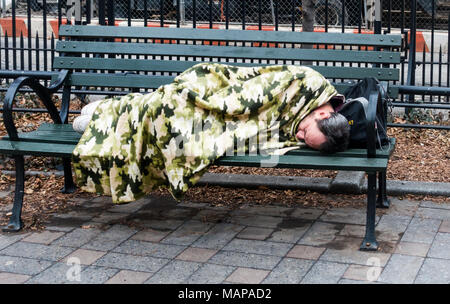 Man schläft auf der Bank in einer kleinen New York City Park, in einem Dschungel, Tarnung Decke abgedeckt Stockfoto