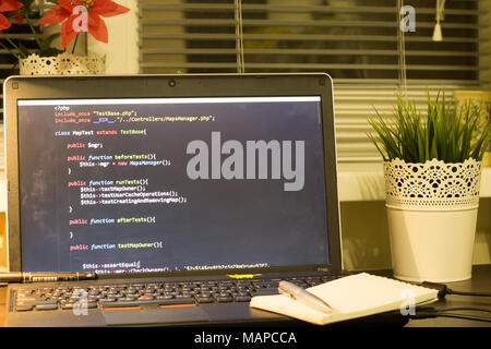 Die Web developer Arbeitsplatz. Laptop mit einem blocknote und ein Metall pen. Die digitale Technologie moderne Hintergrund. Stockfoto
