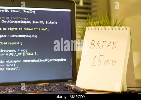 Die Web developer Arbeitsplatz. Laptop mit einem Hinweis zur Seite. Pause nach einem harten Arbeit Konzept. Die digitale Technologie moderne Hintergrund. Stockfoto