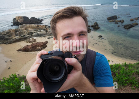 Jungen kaukasischen Mann Fotograf mit Foto Kamera auf Sommerurlaub und Urlaub Reisen Stockfoto