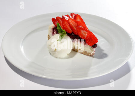 Erdbeerkuchen mit Eis auf weiße Platte Stockfoto