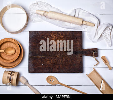 Leeren braunen Küche aus Holz Schneidebrett, Rolling Pin, Sieb, Holz- Platten auf einem weißen Holz- Tabelle, Ansicht von oben Stockfoto
