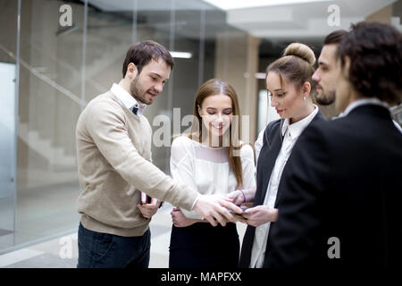 Geschäftsleute, die sich mit digitalen Tablet zusammen im Büro Stockfoto