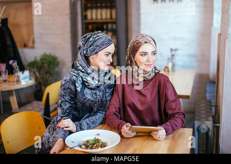 Zwei muslimischen Frauen im Cafe, Shop online über elektronische Tablet Stockfoto