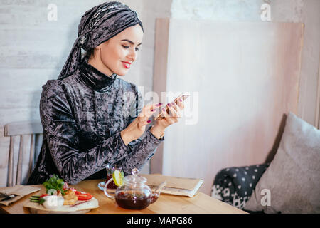 Muslimische Frauen Holding smartphonephone. Denken gute Erinnerungen. Stockfoto