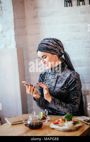 Muslimische Frauen Holding smartphonephone. Denken gute Erinnerungen. Stockfoto