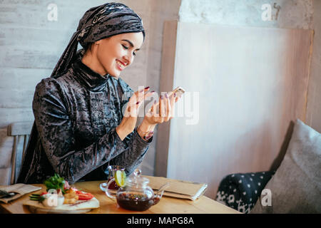 Muslimische Frauen Holding smartphonephone. Denken gute Erinnerungen. Stockfoto