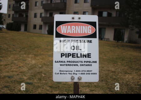Erdöl-Pipeline Warnschild in grüne Wiese. Stockfoto